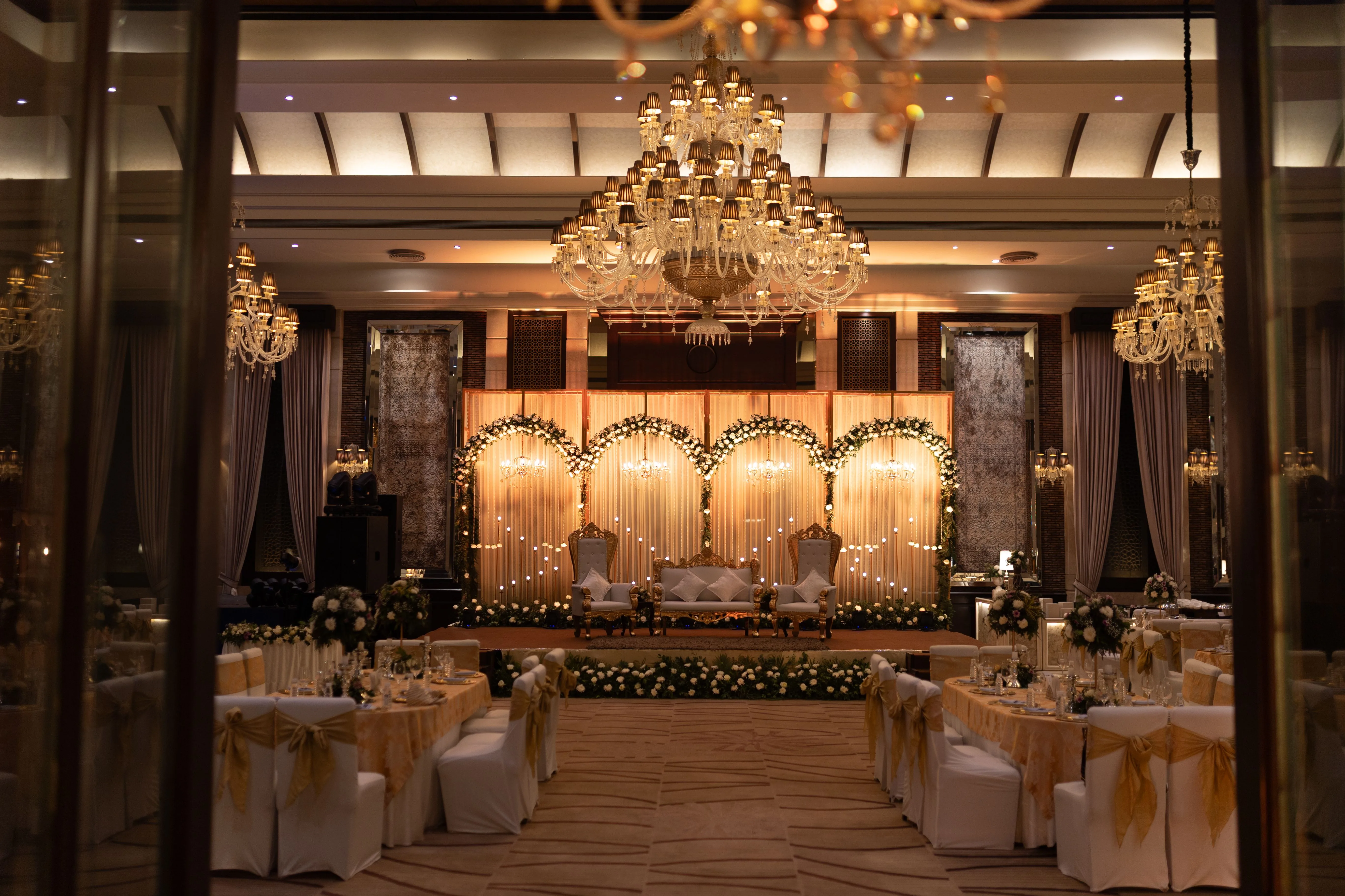 Luxury wedding reception stage with soft florals and warm decor