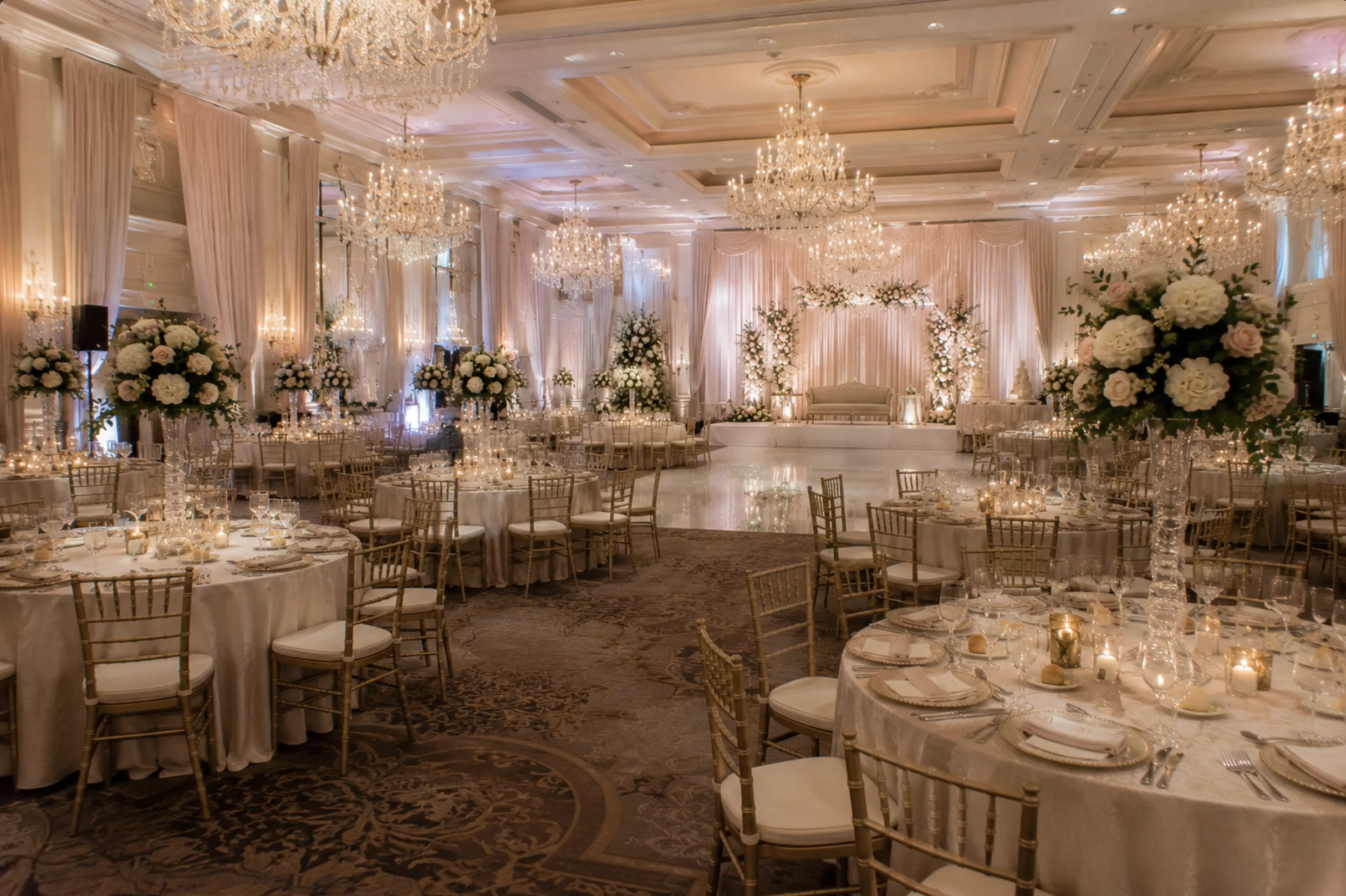 Wide wedding ballroom with reception tables and decor